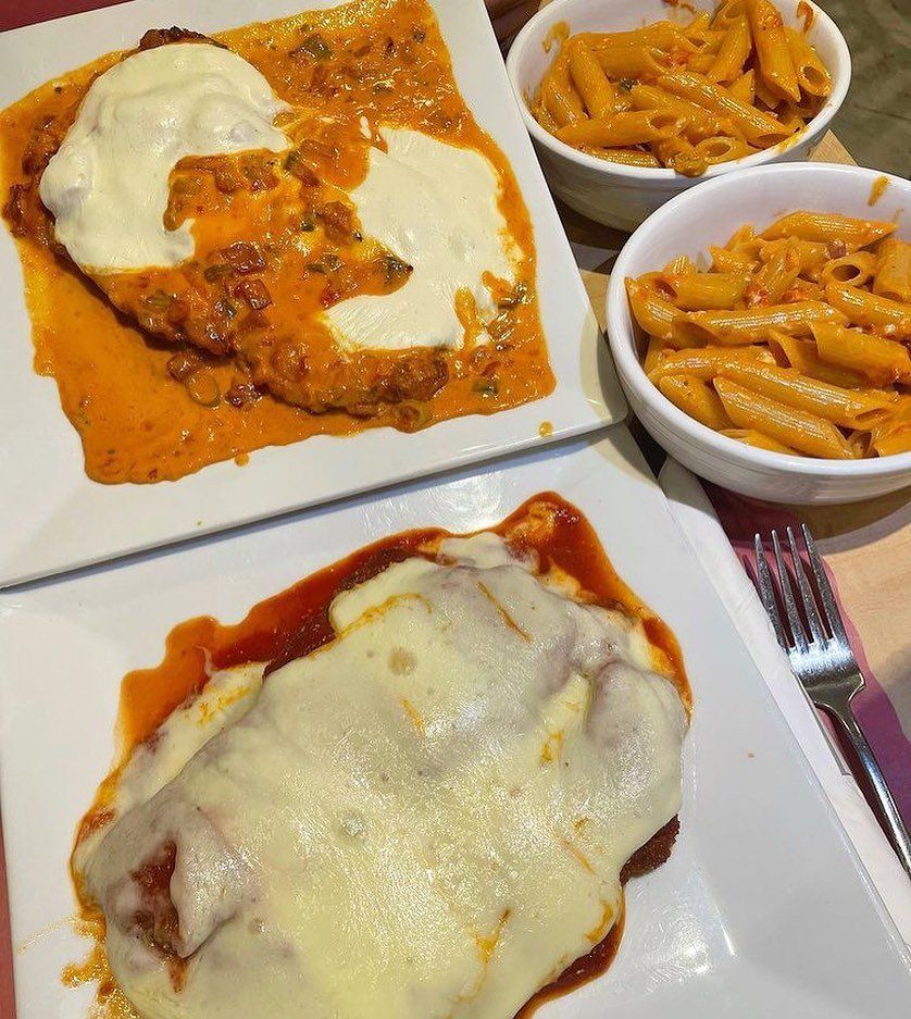 A table topped with plates of food and bowls of pasta.