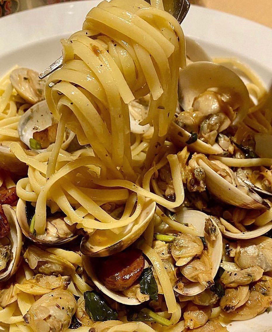 A close up of a plate of noodles and clams