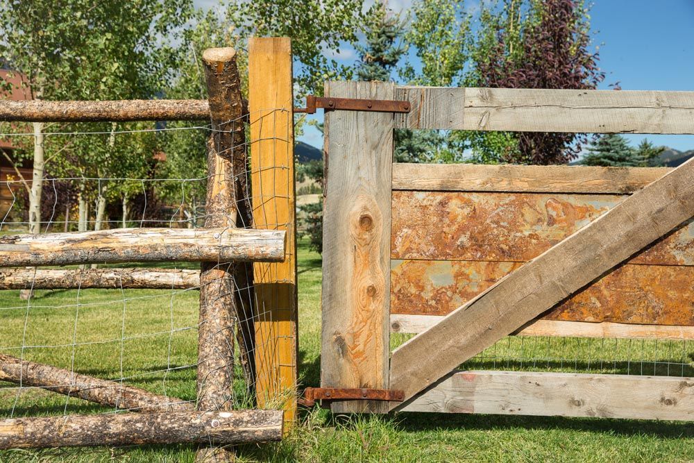 A wooden fence is sitting in the middle of a grassy field.