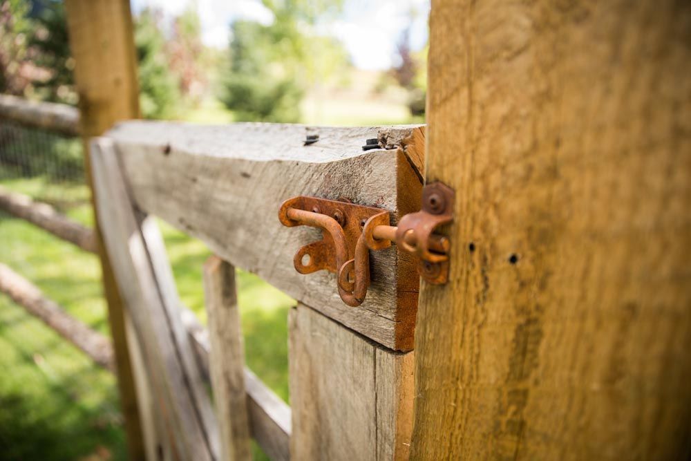 A close up of a wooden gate with a rusty latch.