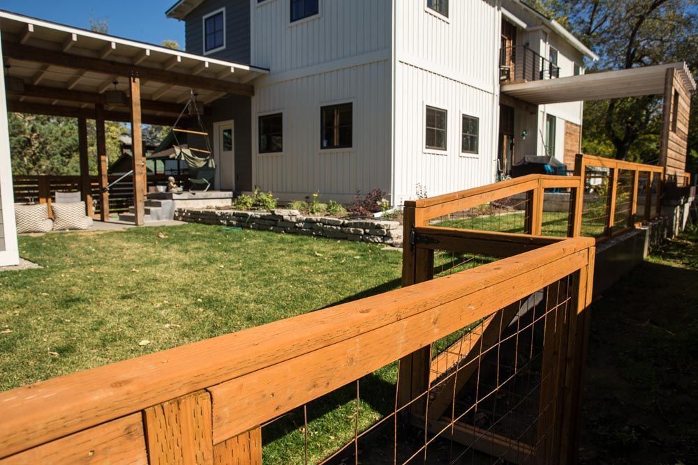 A white house with a wooden fence in front of it.