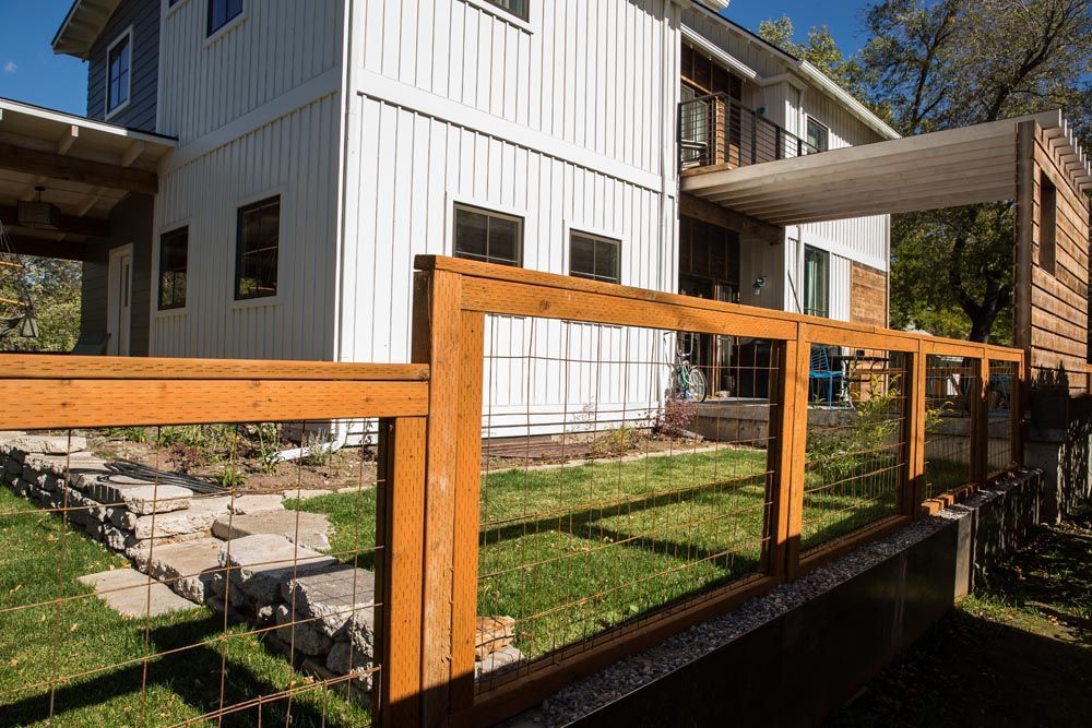 A white house with a wooden fence in front of it.