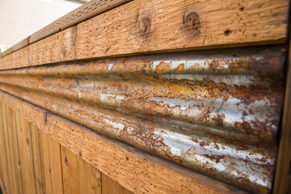 A close up of a wooden wall with a rusty metal border.