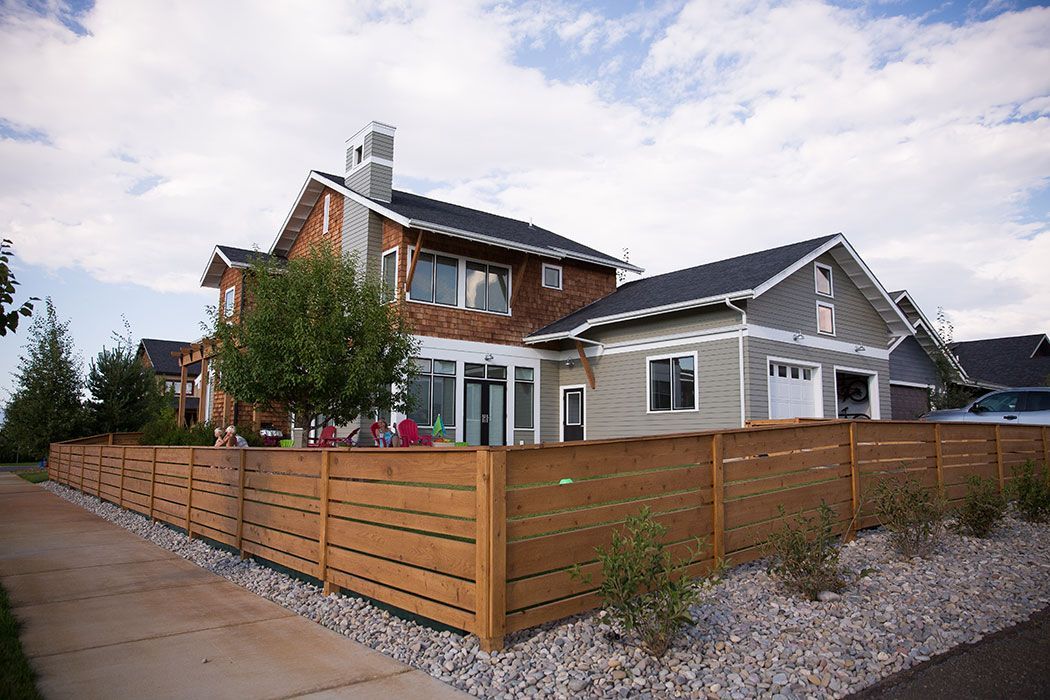 A large house with a wooden fence in front of it.