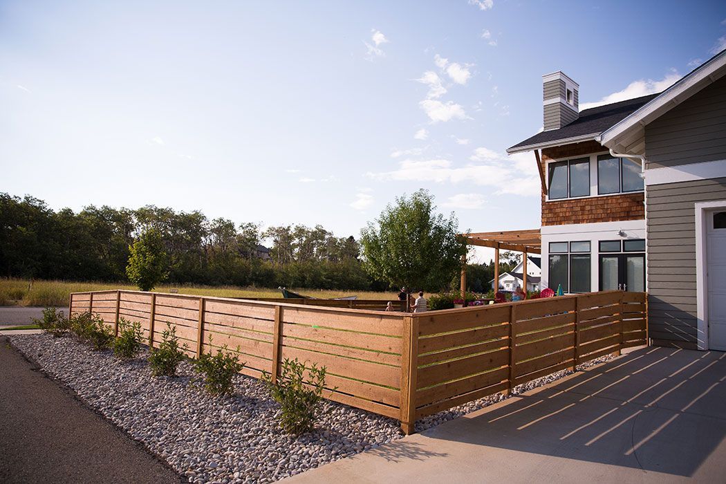 A house with a wooden fence in front of it.