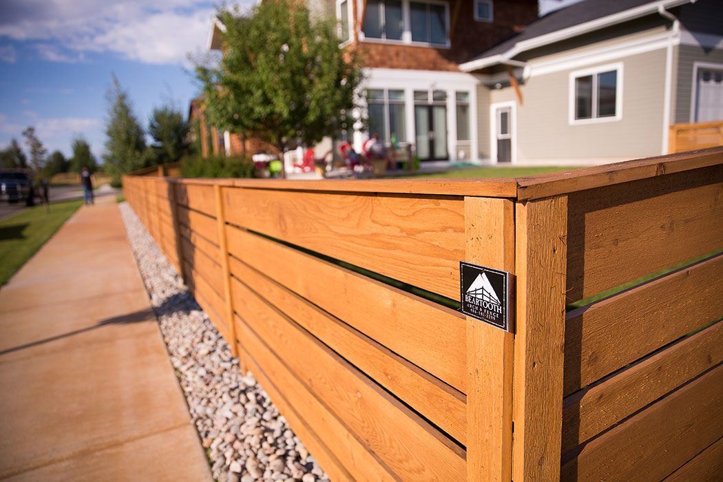 A wooden fence with a house in the background.