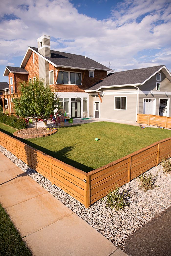 A large house with a wooden fence in front of it.