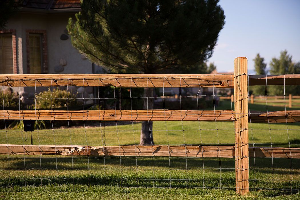 A wooden fence is sitting in the middle of a grassy field.