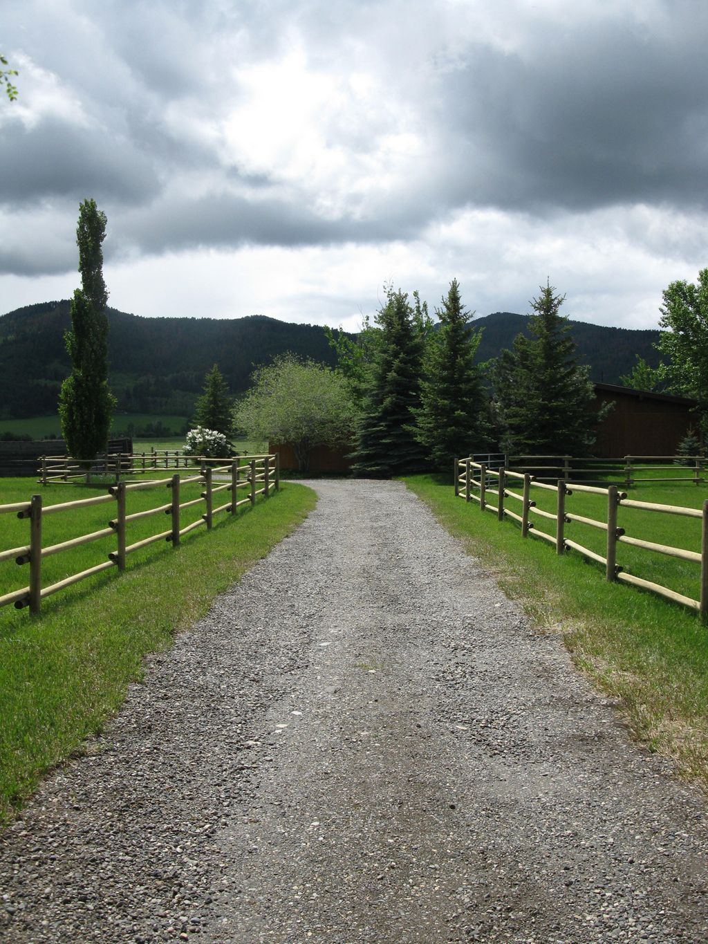 A gravel road with a wooden fence on both sides.
