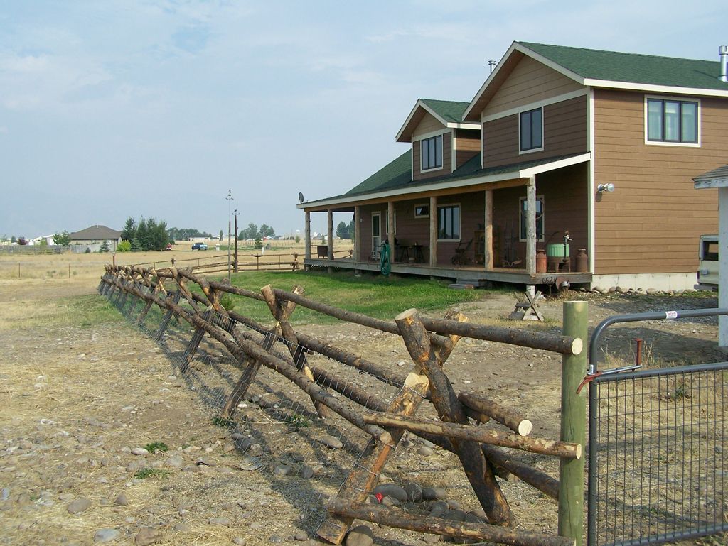 A house with a wooden fence in front of it.