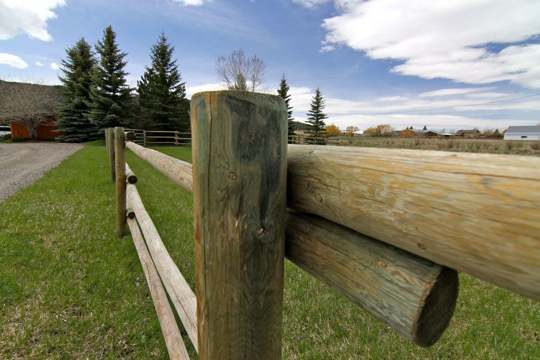 A wooden fence with a house in the background.