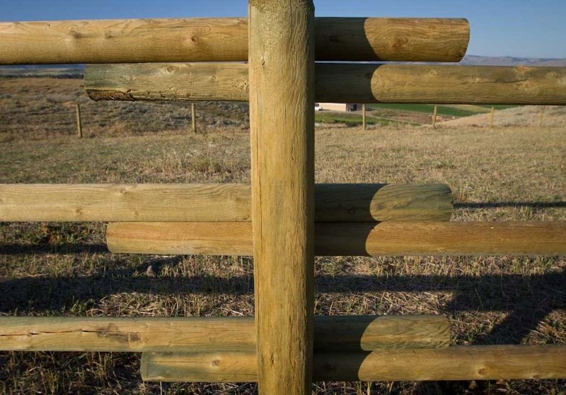 A close up of a wooden fence in a field.