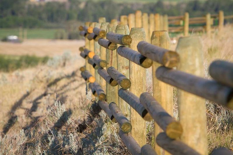 A close up of a wooden fence in a field.