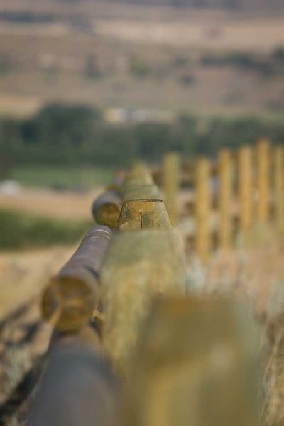 A blurry picture of a wooden fence with a field in the background.