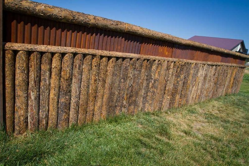 A wooden fence is sitting in the middle of a grassy field.