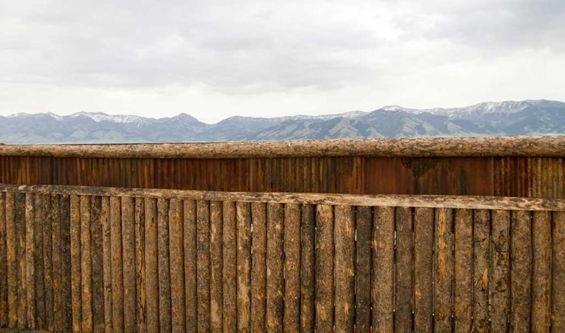 A wooden fence with mountains in the background.