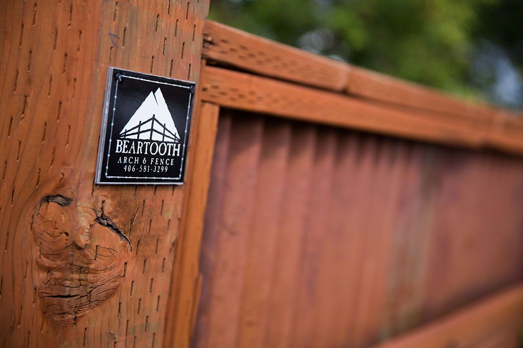 A close up of a wooden fence with a sticker on it.