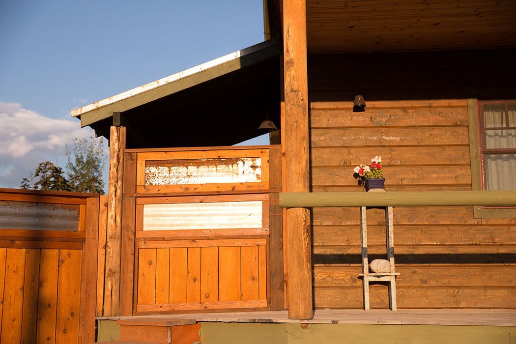 A wooden house with a porch and a ladder on it.
