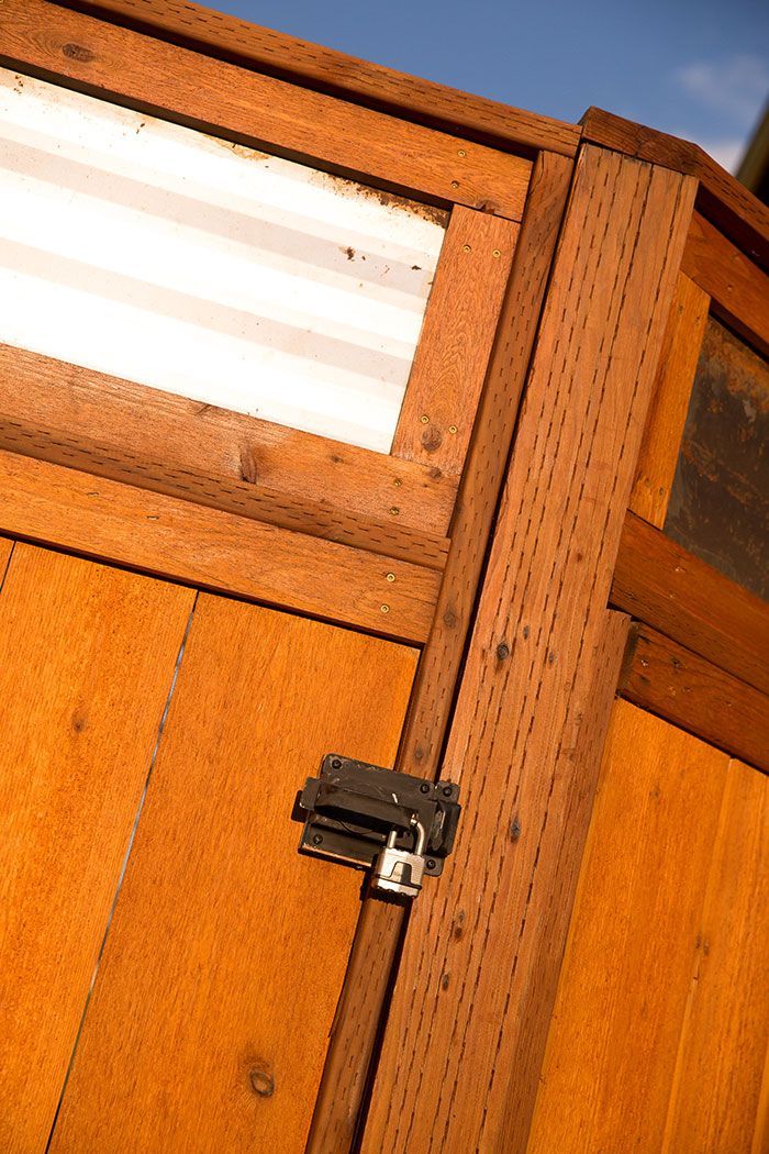 A close up of a wooden door with a padlock on it.