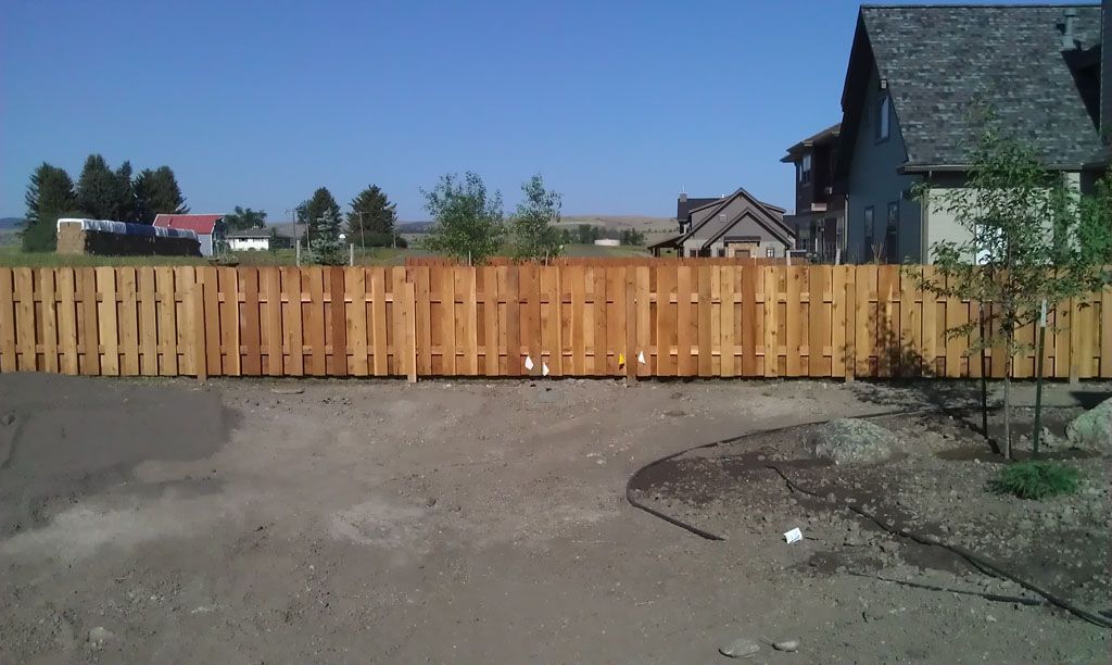 A wooden fence with a house in the background.