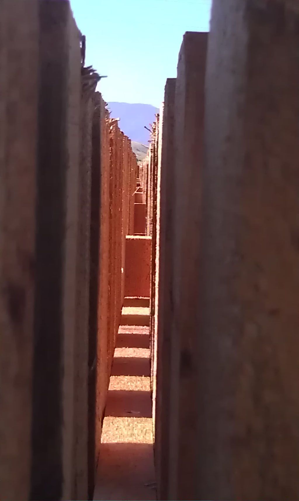 A narrow alleyway with a mountain in the background.