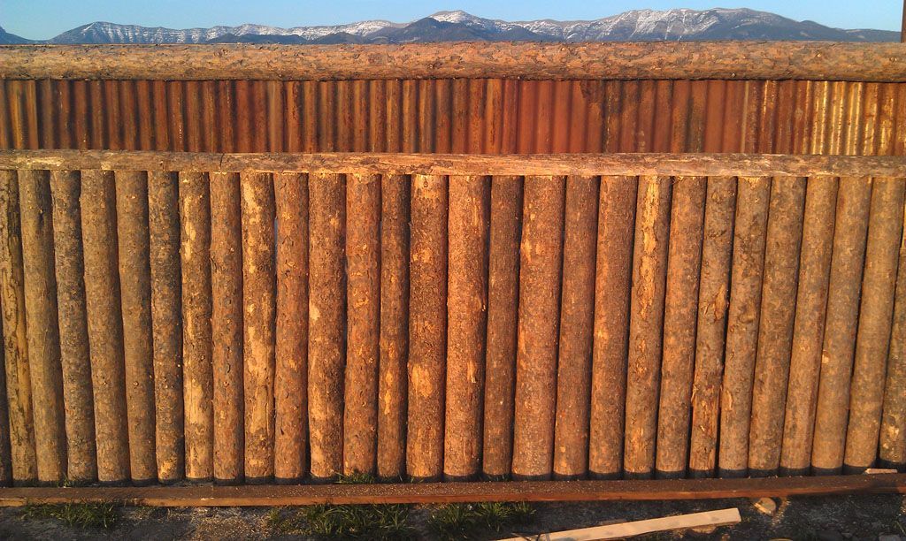 A wooden fence with mountains in the background.
