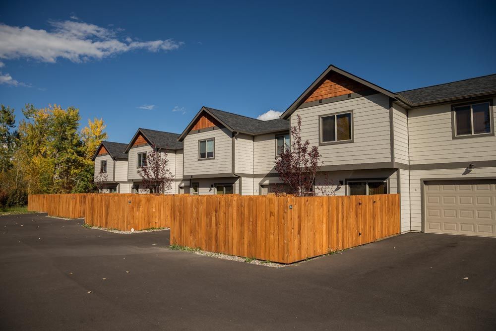 A row of houses with a wooden fence in front of them.
