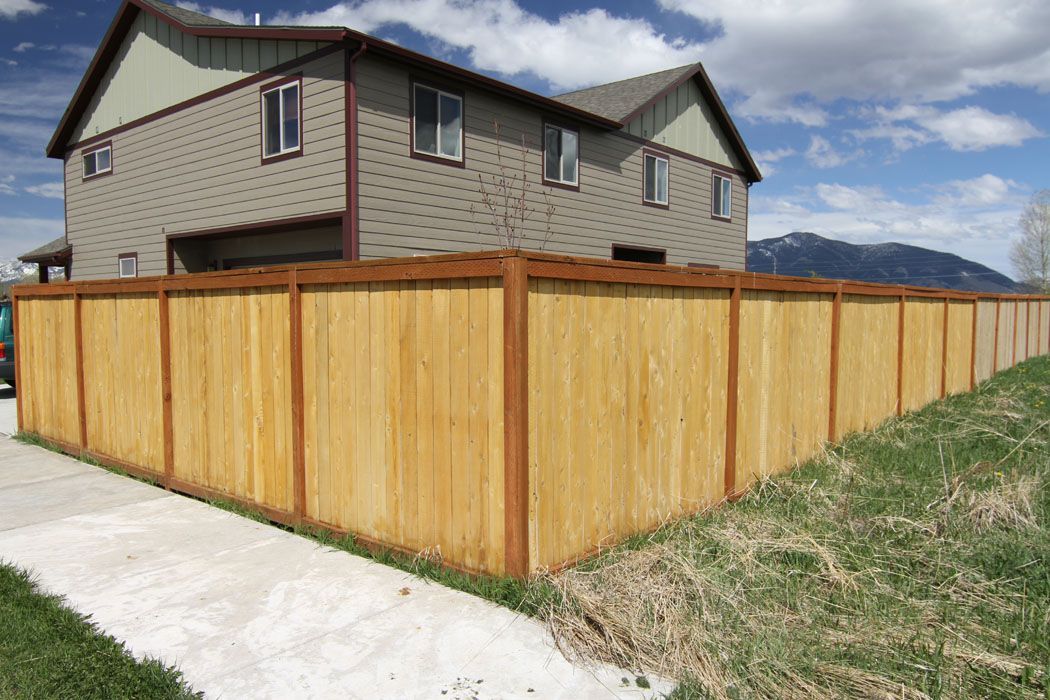 There is a wooden fence in front of a house.
