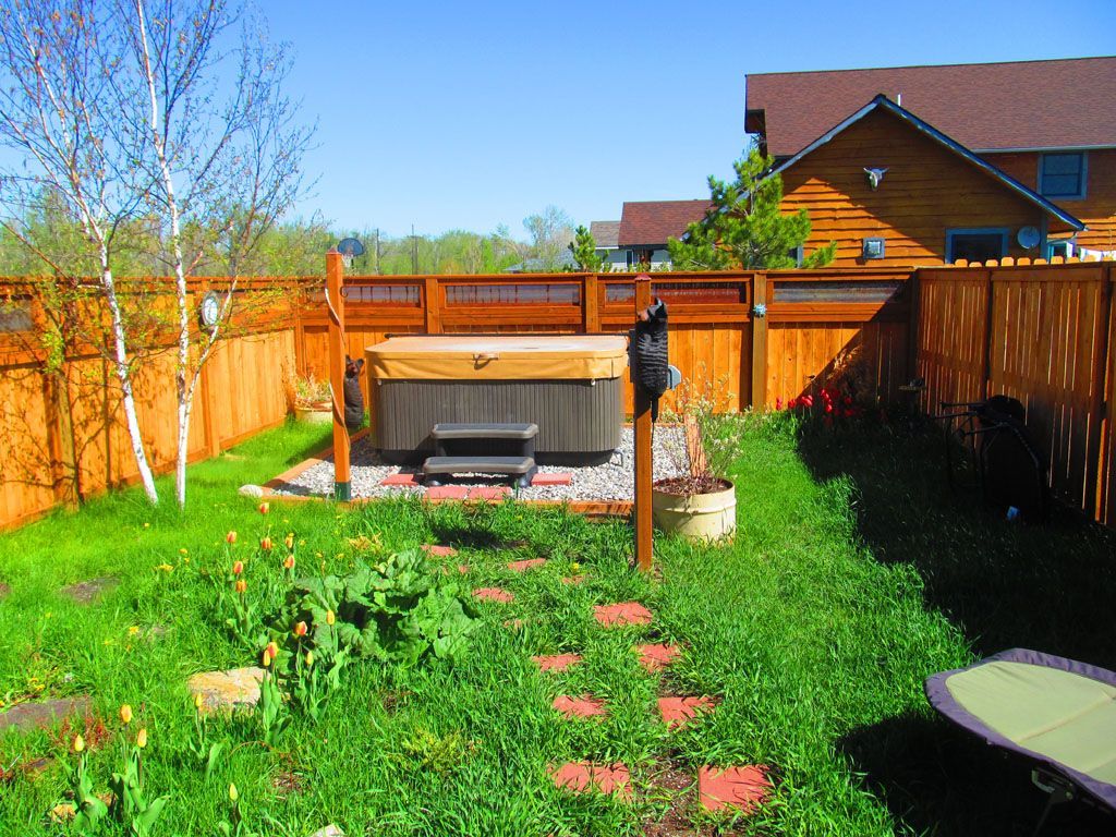 There is a hot tub in the backyard of a house.