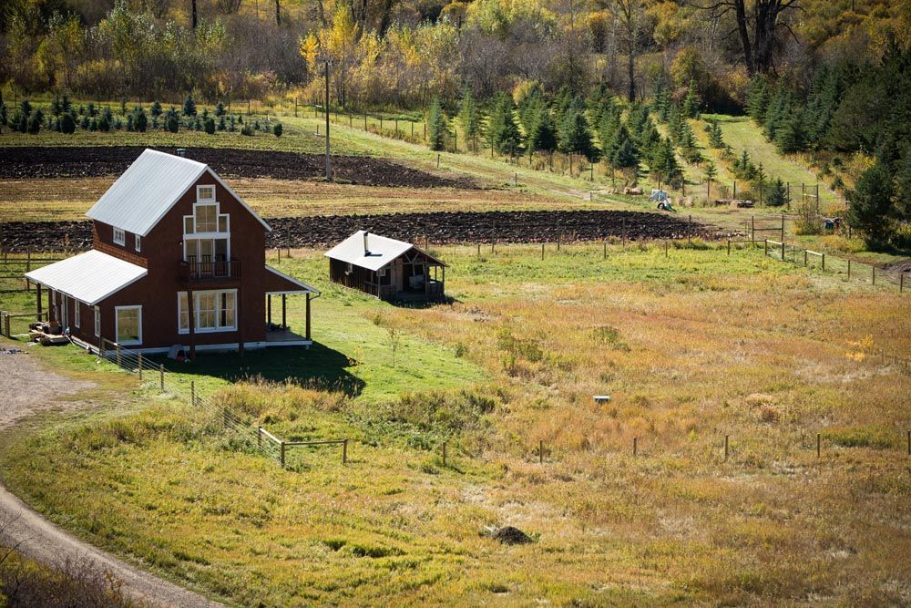 An aerial view of a house in the middle of a field.