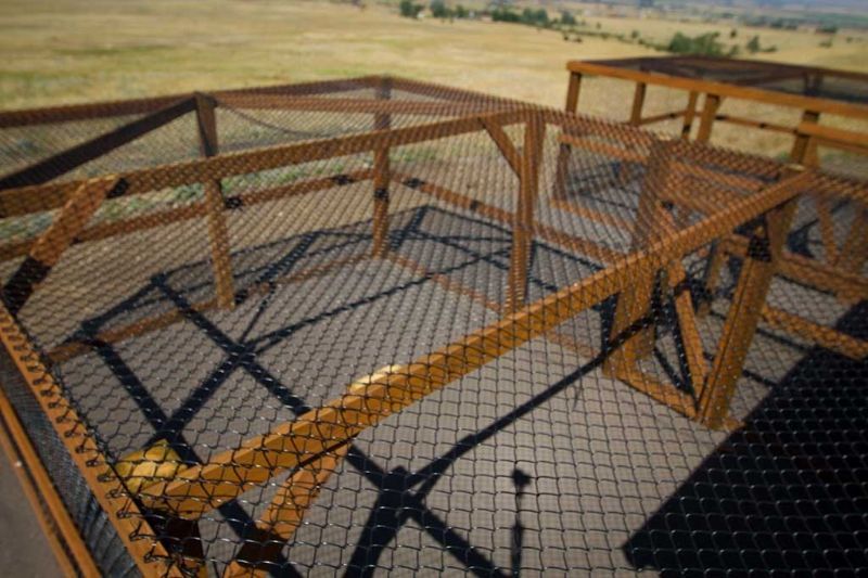 A wooden structure with a chain link fence around it.