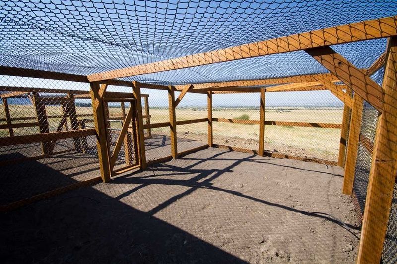 A wooden structure with a fence and a net on top of it.