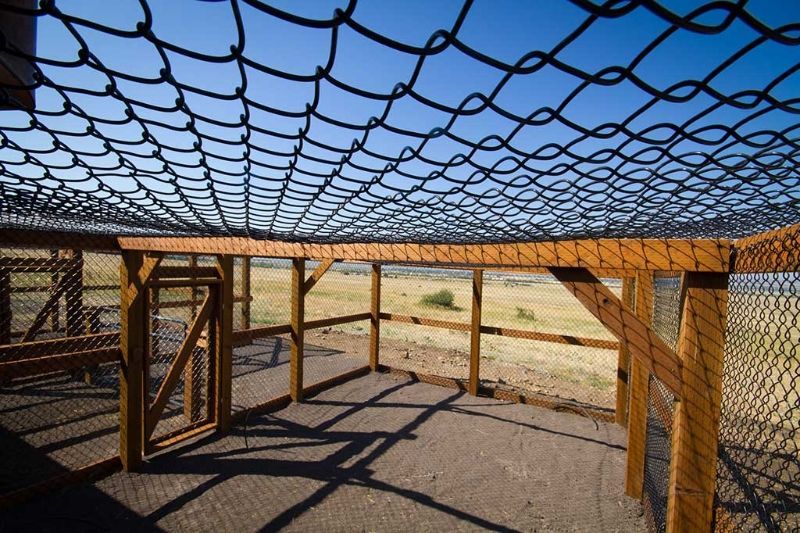 A wooden structure with a chain link fence on top of it.