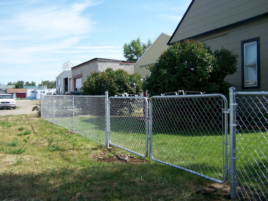 A chain link fence is in front of a house.