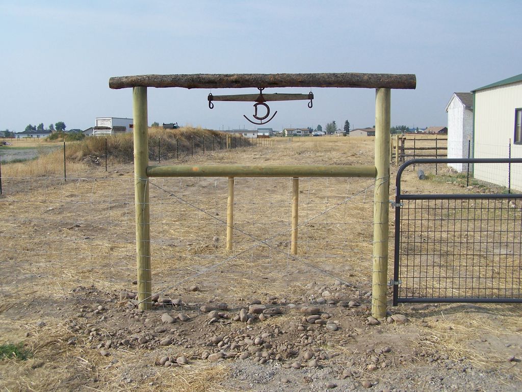 A wooden post with a horseshoe hanging from it.