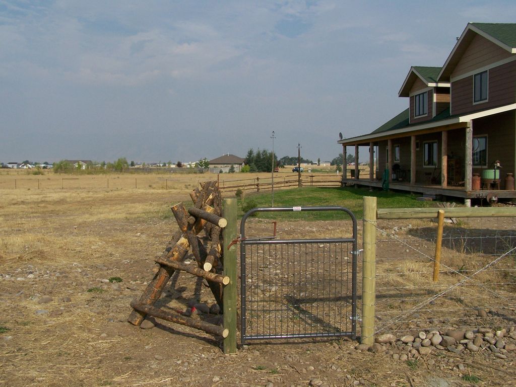 A fence with a gate in front of a house.