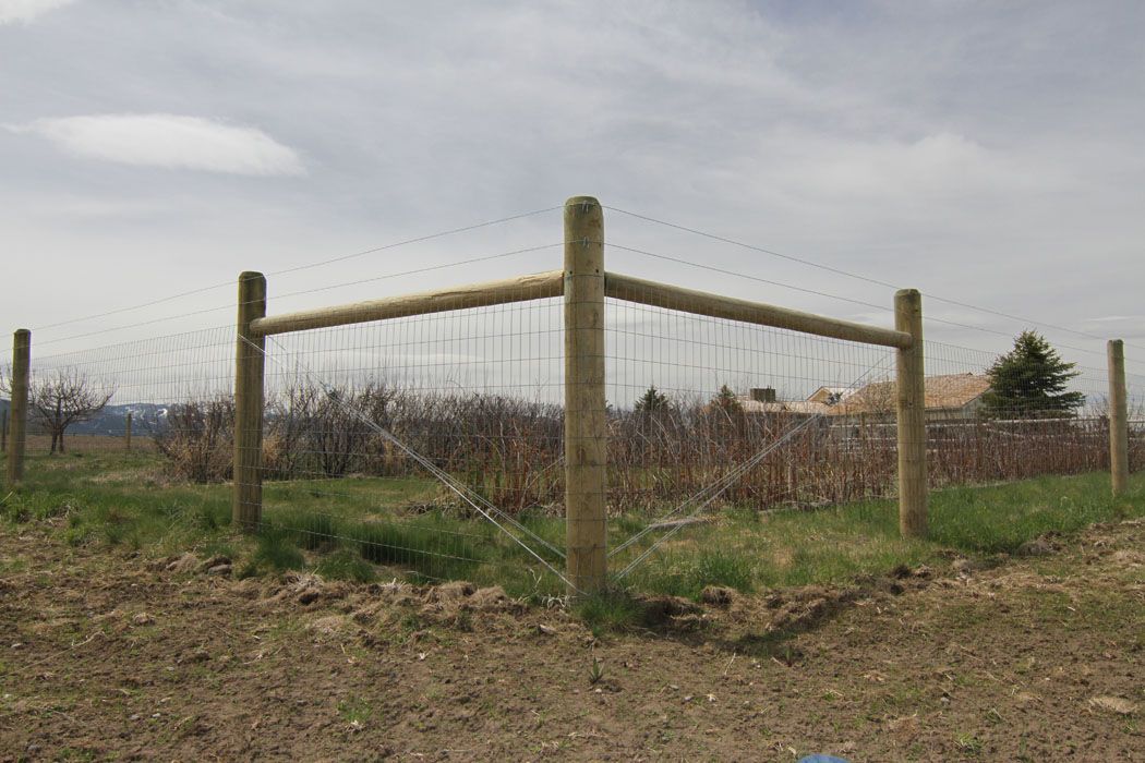 A wooden fence is in the middle of a field.