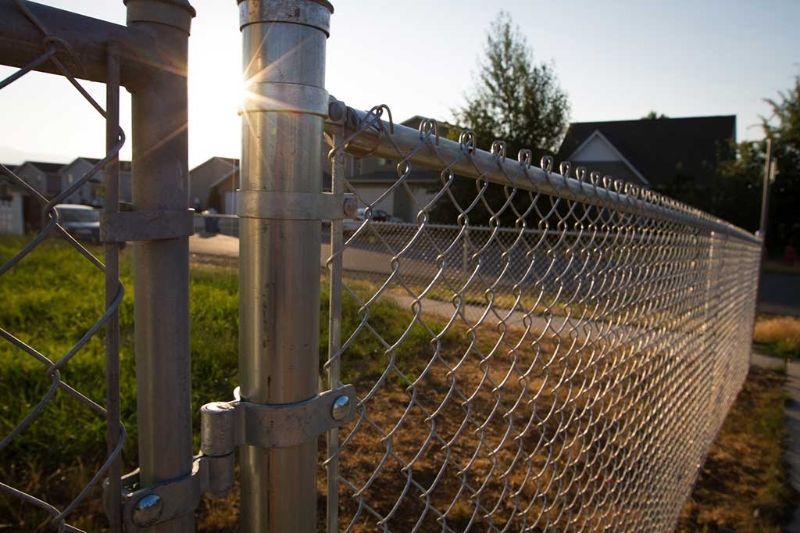 A chain link fence with the sun shining through it.