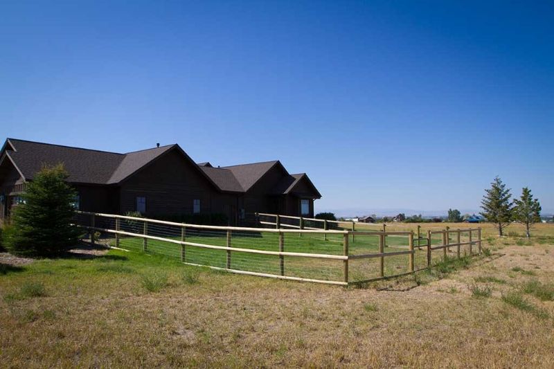A large house with a wooden fence in front of it.