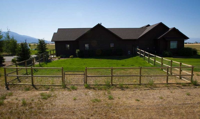 A large house with a wooden fence in front of it.