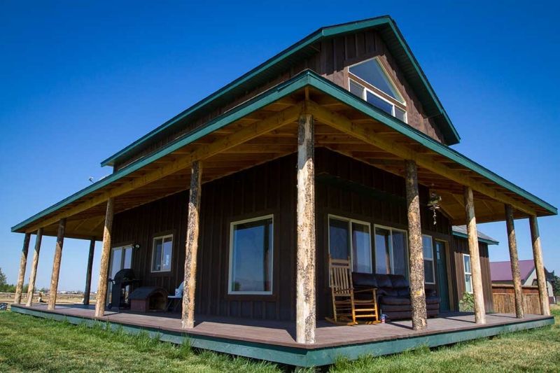 A house with a porch and chairs on it.