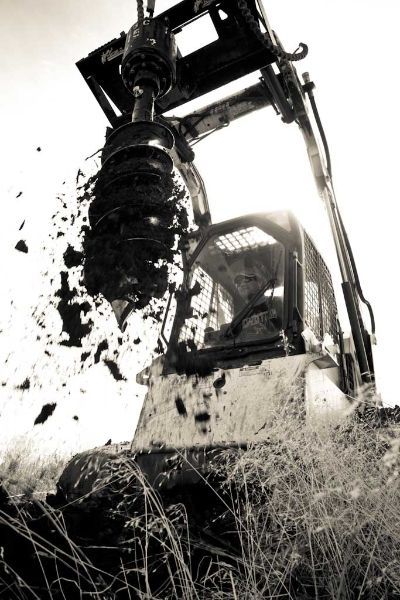 A black and white photo of a bulldozer digging in the dirt.