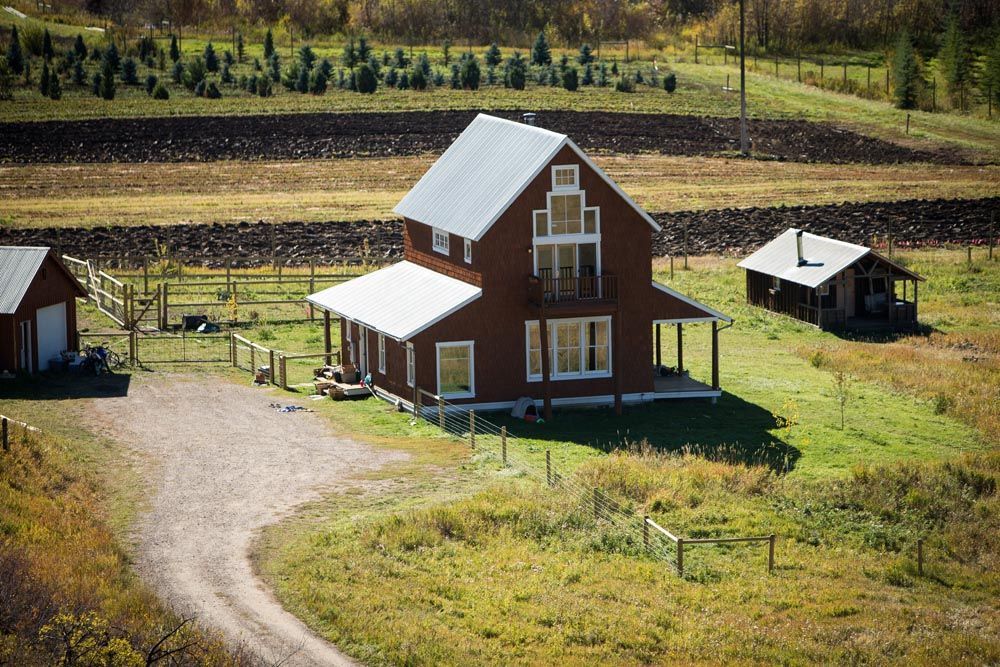 An aerial view of a house in the middle of a field