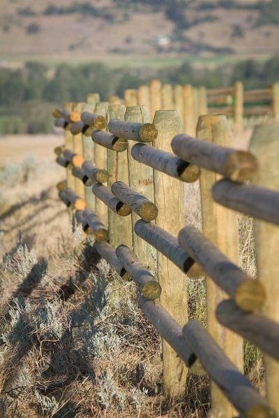 A close up of a wooden fence in a field.