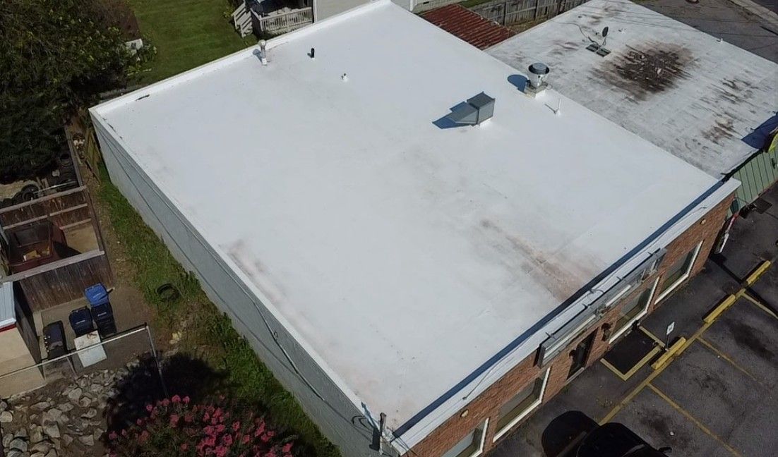 An aerial view of a building with a flat, white roof.