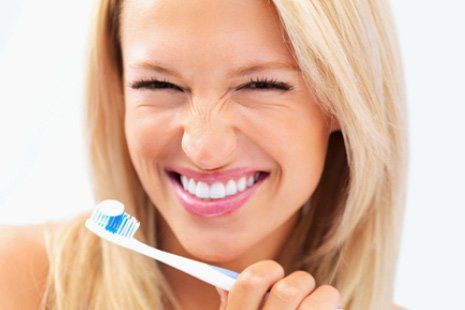 Woman with toothbrush smiling