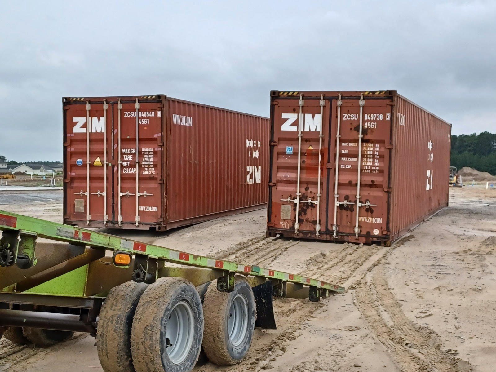 Two shipping containers are sitting on top of a trailer.