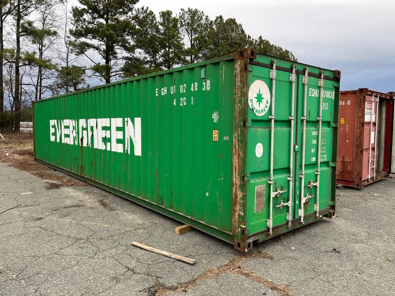 A green shipping container with the word evergreen on it.