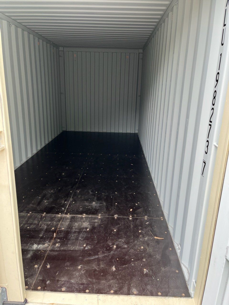 The inside of a shipping container with a wooden floor.