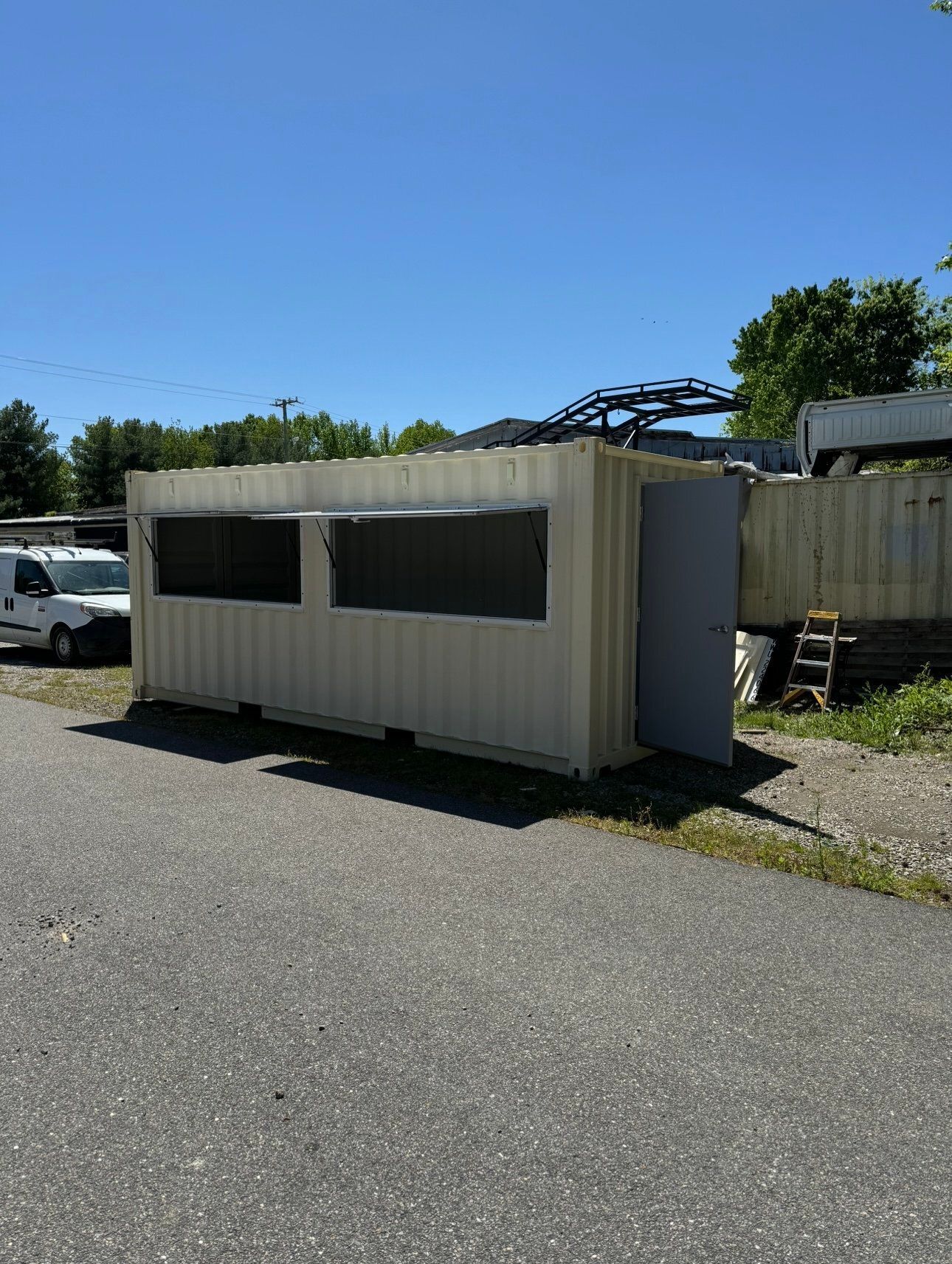 A white container is parked on the side of the road.